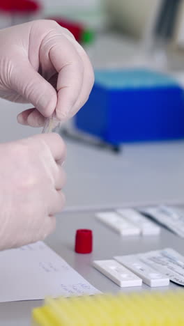 medical assistant works with samples. hands of medical worker in sterile gloves uses pipette during test analysis in the laboratory. vertical video