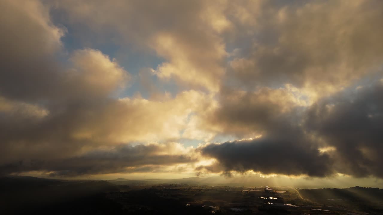 Drone panning above Zacatlán Valley, showing fast-moving golden clouds illuminated by the rising sun
