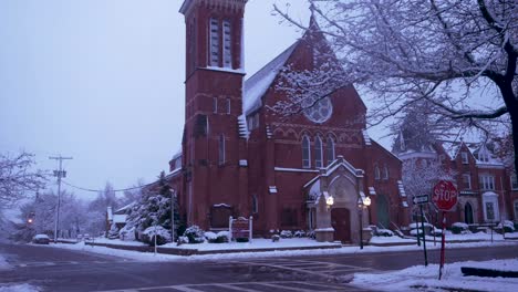 slow pan down of a large brick church in a quiet nj town while it snows