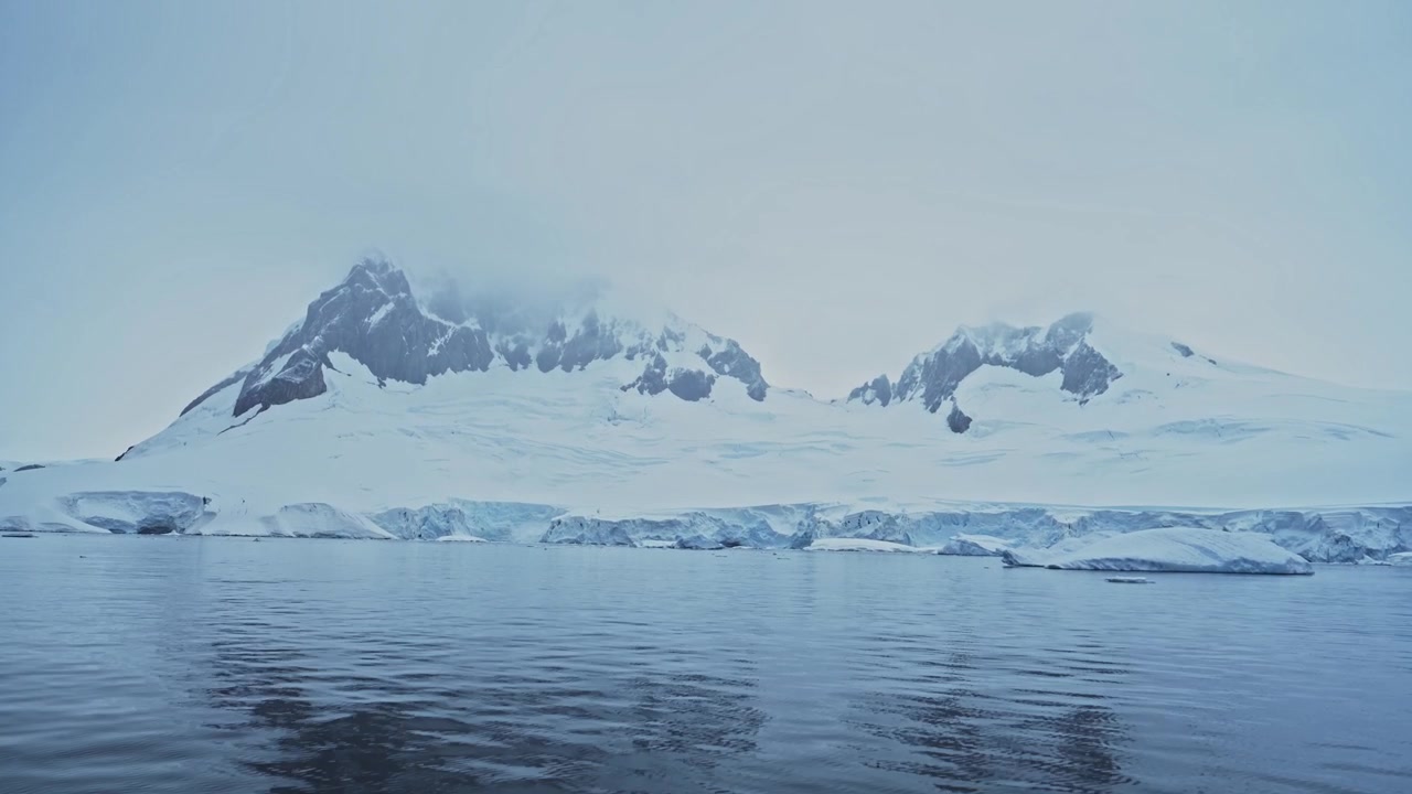 Montanhas de Inverno e Geleira na Costa da Antártica. Cenário Costeiro Frio e Azul com Gelo Glacial e Água do Mar. Bela e Dramática Paisagem da Península Antártica.