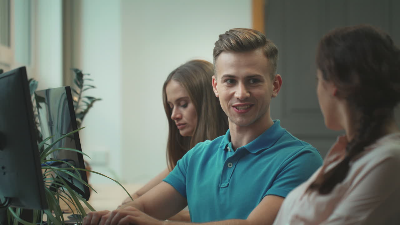 un equipo joven trabajando en un espacio abierto. un hombre sonriente coqueteando con una mujer en el coworking.