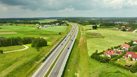 Luftaufnahme-Einer-Autobahn,-Die-Durch-Eine-Ländliche-Gegend-Mit-Angrenzenden-Wohngebieten-Führt