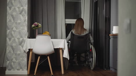 housewife moves wheelchair closer to look out small window