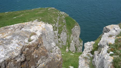 Grasbewachsene-Felsige-Große-Orme-klippenkante-Mit-Blick-Auf-Die-Berge-Mit-Blick-Auf-Das-Malerische-Meer