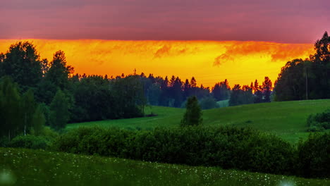 Wunderschöner-Orangefarbener-Sonnenuntergangshimmel-über-Grünen-Sanften-Hügeln-Und-Feldern