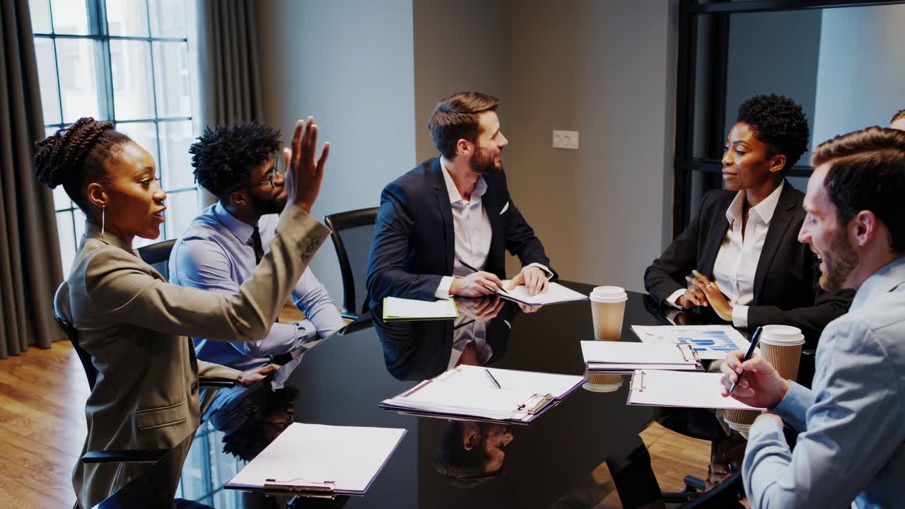 Video of a diverse business meeting with professionals discussing around a table