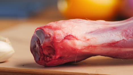 raw lamb shank on wooden cutting board