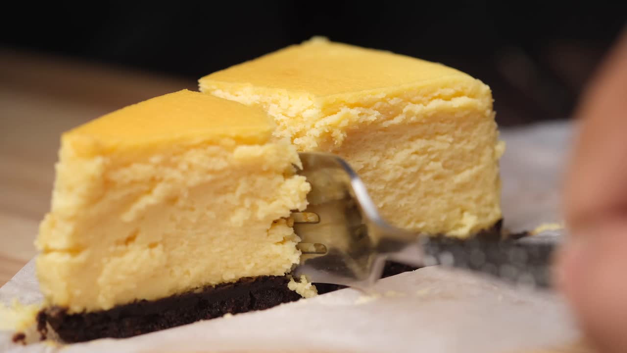 맛있는 치즈케이크 조각이 잘라지고 있습니다.