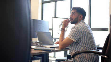 thinking at desk, man with laptop and robotic arm in modern office