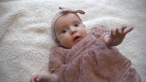 top down view of dressed up baby girl on blanket, slow motion