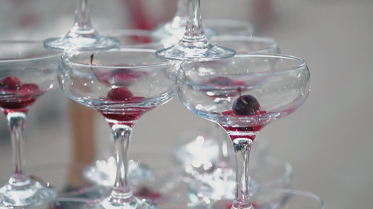 Pyramide af glas, hvor der er et kirsebær i hvert glas.