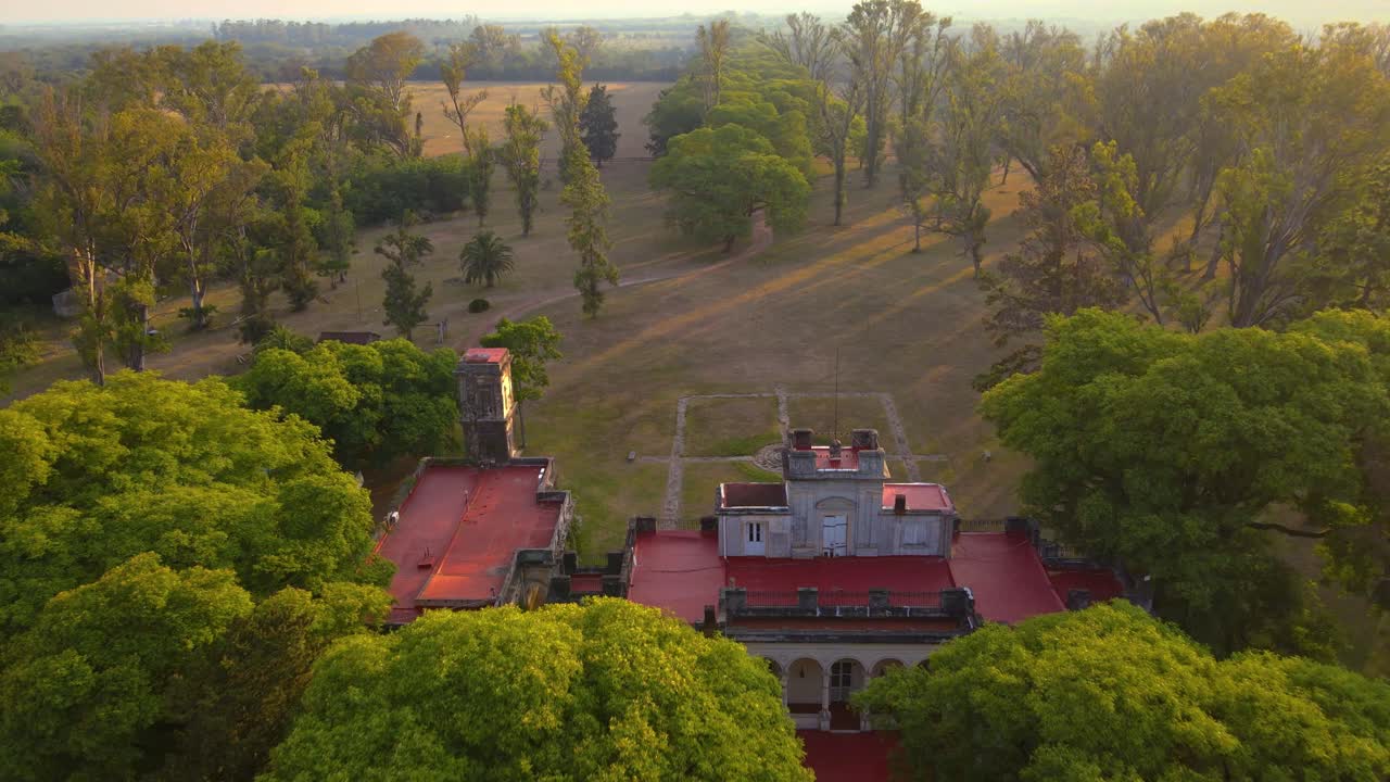 Drone shot flying backwards, panning up to reveal the estancia Santa C&aacute;ndida during golden hour