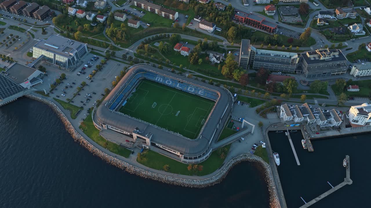 Udsigt i den gyldne time over en fodboldbane i Molde by, set fra oven.