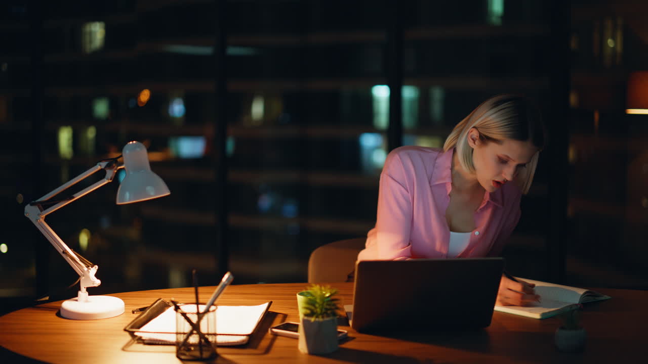 Woman working late in office at night