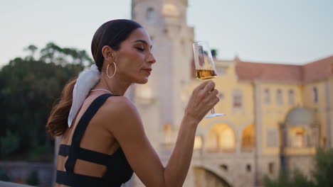 una mujer disfrutando de champán junto a un castillo.