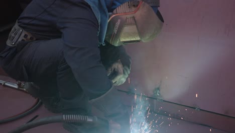masked man repairing a ship with welding machine