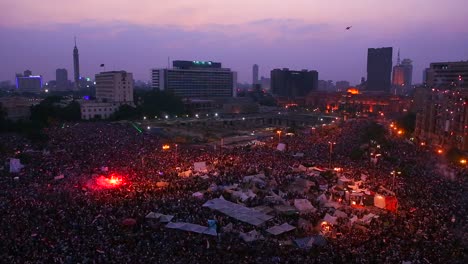 fireworks go off above protestors gathered in tahrir square in cairo egypt as dawn breaks