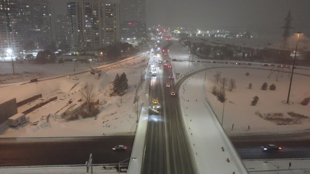 Multiple Winter Service Vehicles Plowing Streets at Night, Aerial Shot