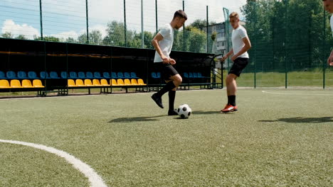 male soccer players playing on a street football pitch on a sunny morning