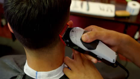 hombre recibiendo su cabello recortado con trimmer 4k