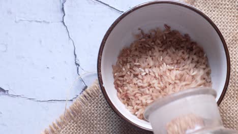 pouring brown rice into a bowl