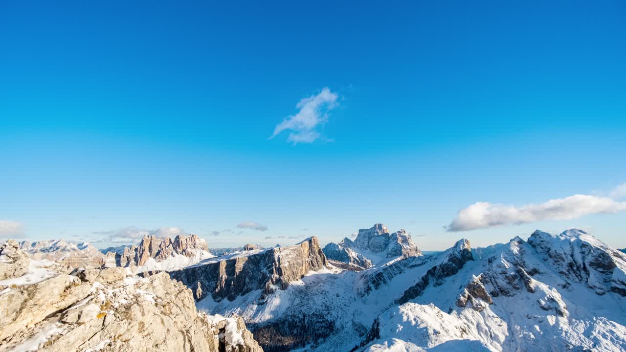 lapso de tiempo: nubes blancas moviéndose en el cielo azul sobre picos nevados de dolomitas en verano