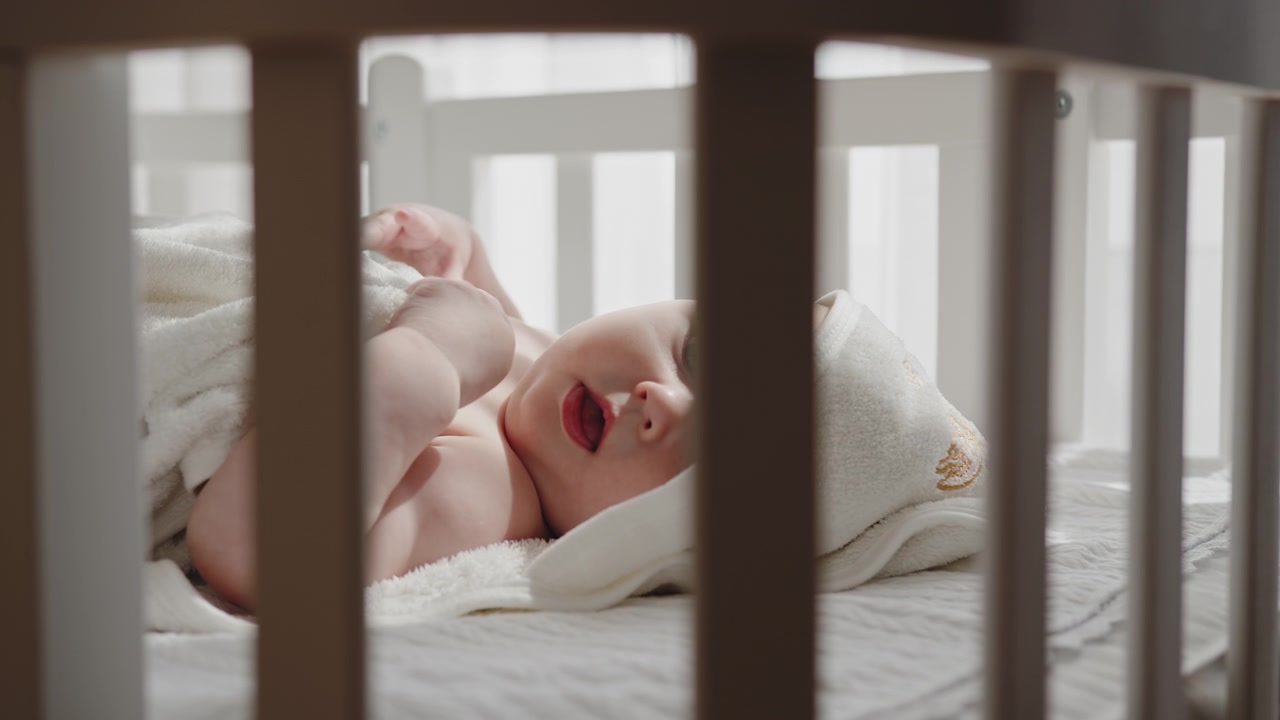 Newborn baby rests peacefully in crib gazing upwards with innocent curiosity creating a serene and