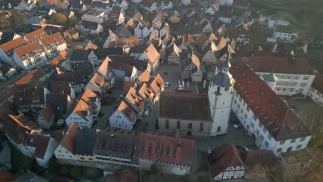 Slow-aerial-video-over-a-small-German-village-with-a-church-in-the-evening