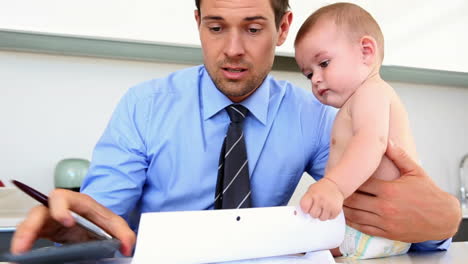 stressed father calculating bills with his baby