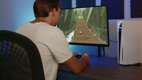 boy gaming on his playstation 5 with a ps5 controller in an rgb led room at night, side view wide