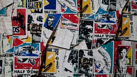 a close-up of a wall covered in vintage posters with a grunge aesthetic, creating a retro video