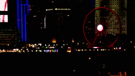ferris wheel and skyscrapers illuminated at night