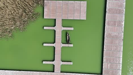 fotografía ascendente de una plataforma de pesca en pilotes junto a un lago en el norte de grecia | fotografía de arriba hacia abajo de una plataforma para pescar en aguas verdes turbias