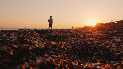 silueta de un hombre corriendo cerca del mar al atardecer
