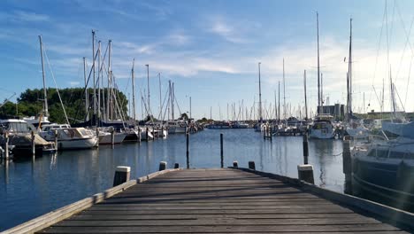 Abendlicher-Zeitraffer-Eines-Holzstegs-An-Einem-Kleinen-Holländischen-Hafen-Mit-Zahlreichen-Segelbooten