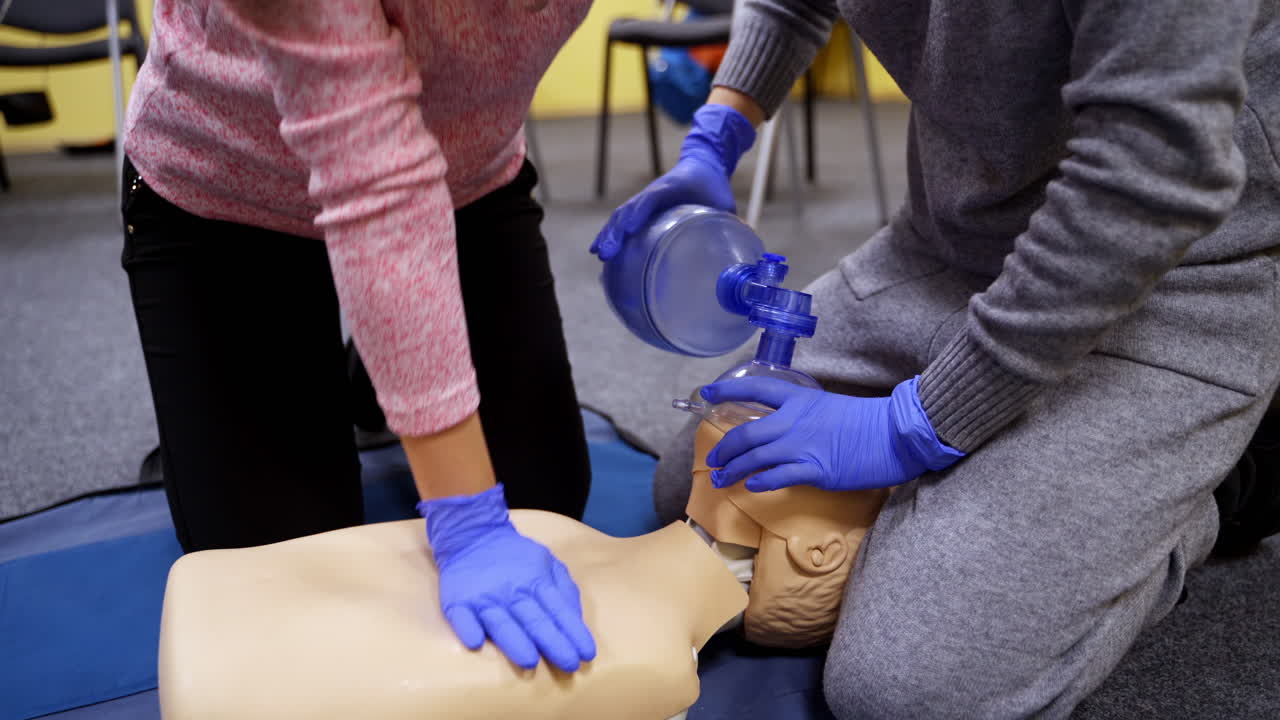 Medical practice to save life. Students in medical gloves learning to do a cpr on a dummy in training center. Adult cpr training and first aid.