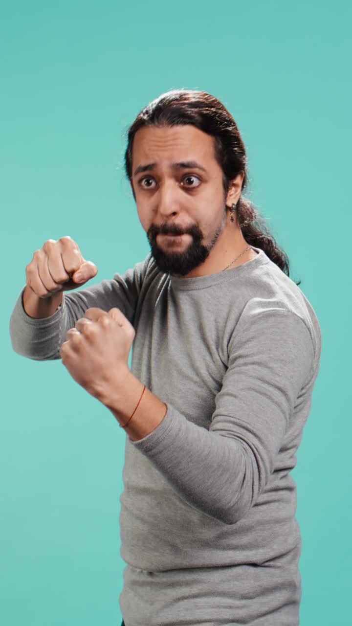 Vertical video Man pretending to fight, throwing punches, holding defensive guard