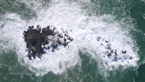 olas blancas y espumosas chocan contra una roca de coral en el océano en indonesia