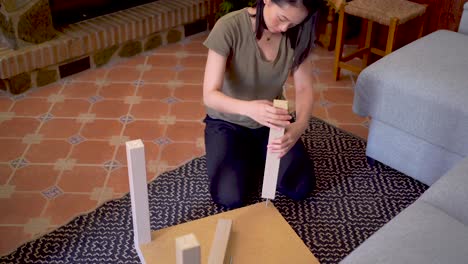 Asian-woman-assembling-table-in-living-room