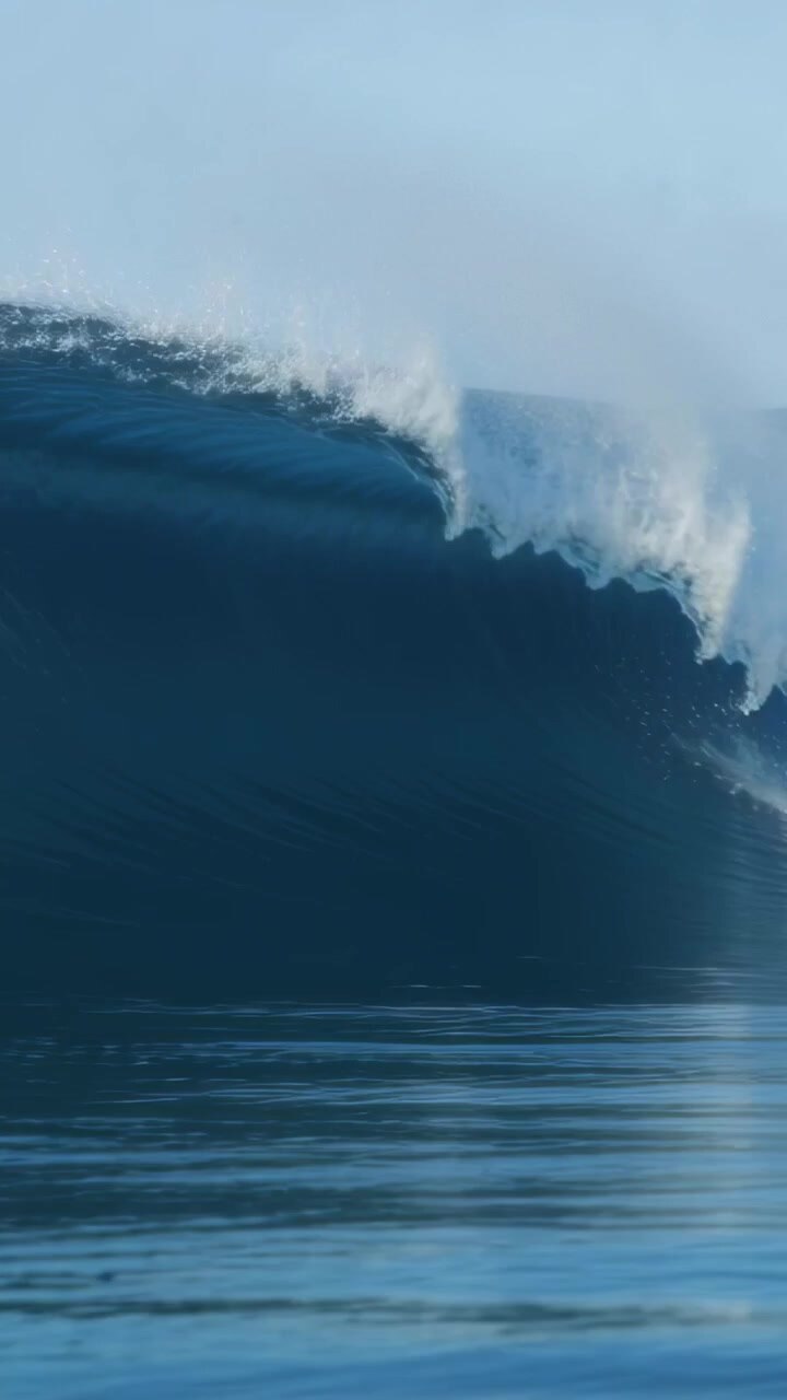 Vertical video: Forming ocean wave rising, curling and breaking offshore with foam spray from wind