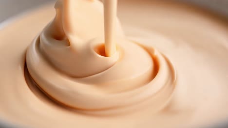 close up of creamy liquid being poured into a bowl