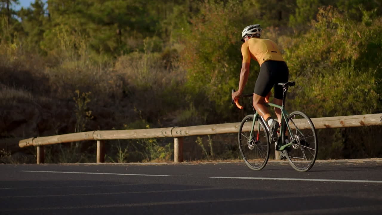 Cycling up a mountain serpentine in slow motion, the athlete beholds the island's picturesque view, reflecting the commitment to a healthy lifestyle