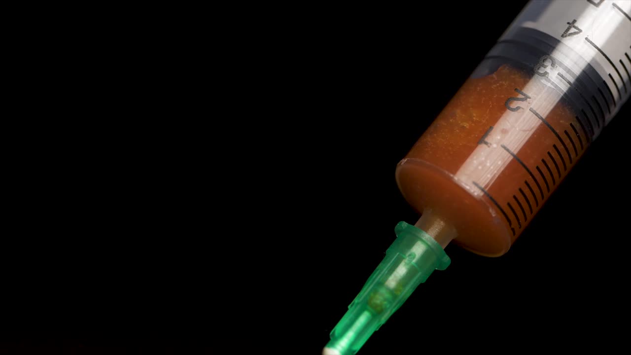 jeringa utilizada con líquido marrón