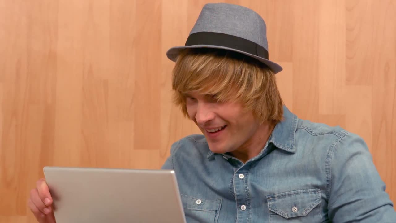 hipster triunfando mientras mira en la tableta