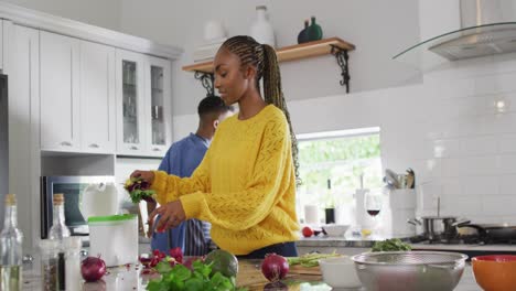 happy african american couple preparing meal in kitchen