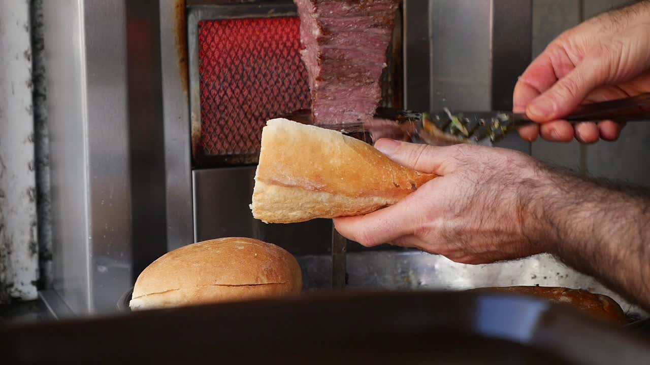 Chef Slicing Doner Kebab Meat into Fresh Bread