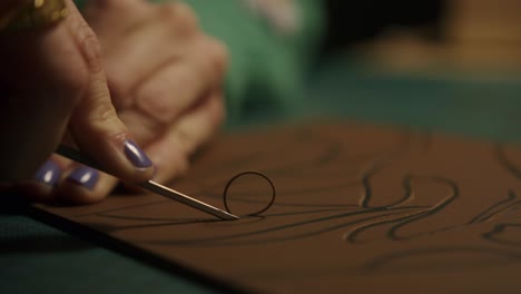 artista cortando cuero con una herramienta de precisión