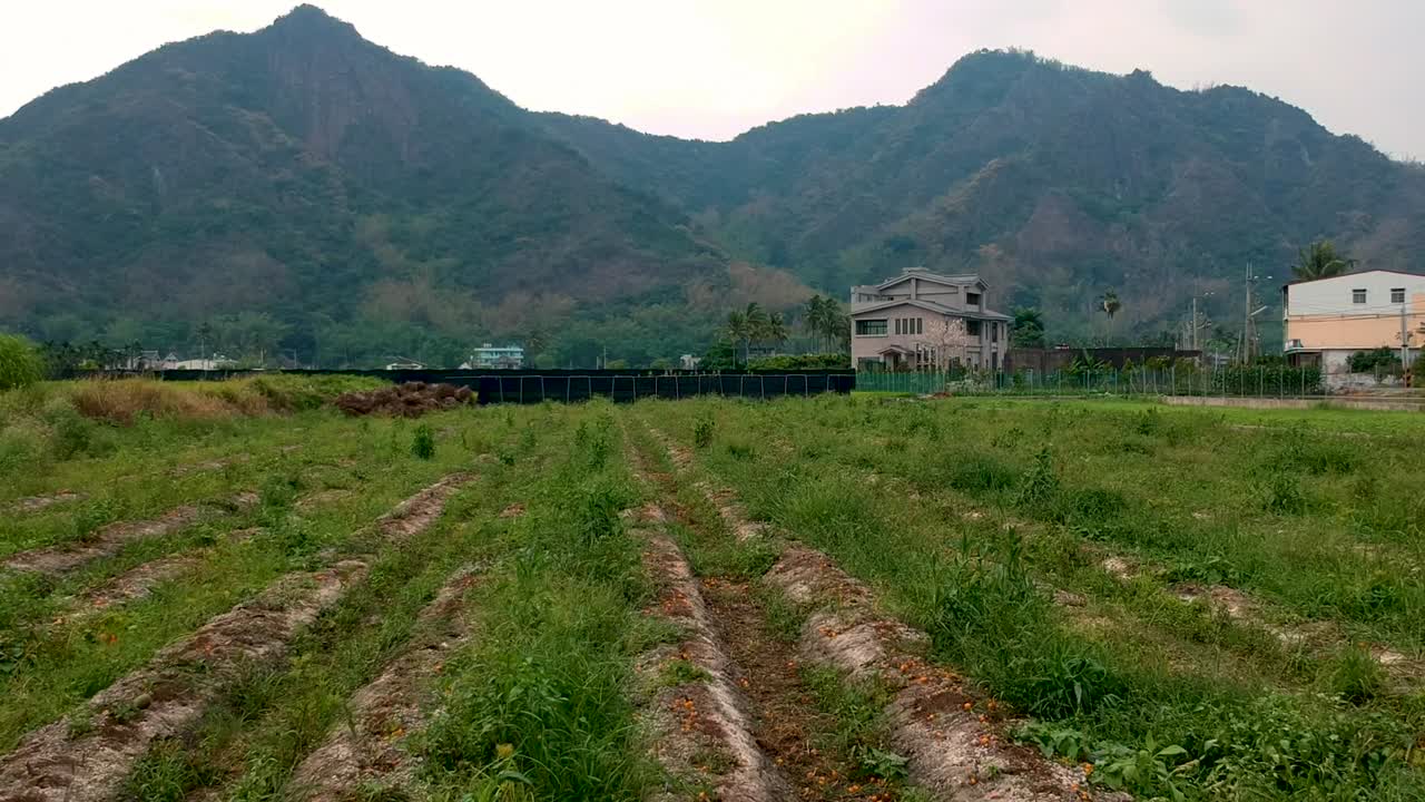 Rolling drone shot view of the beautiful green lustful mountain with a farm base