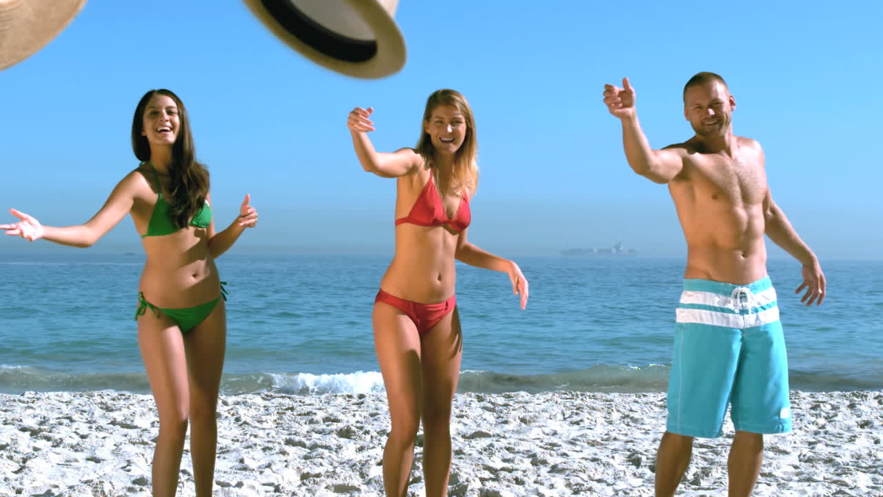 매력적인 친구들이 동시에 모자를 던지고 있습니다.