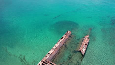 Forward drone shot capturing the iconic shipwreck and turquoise waters of Puerto Viejo beach in Costa Rica.